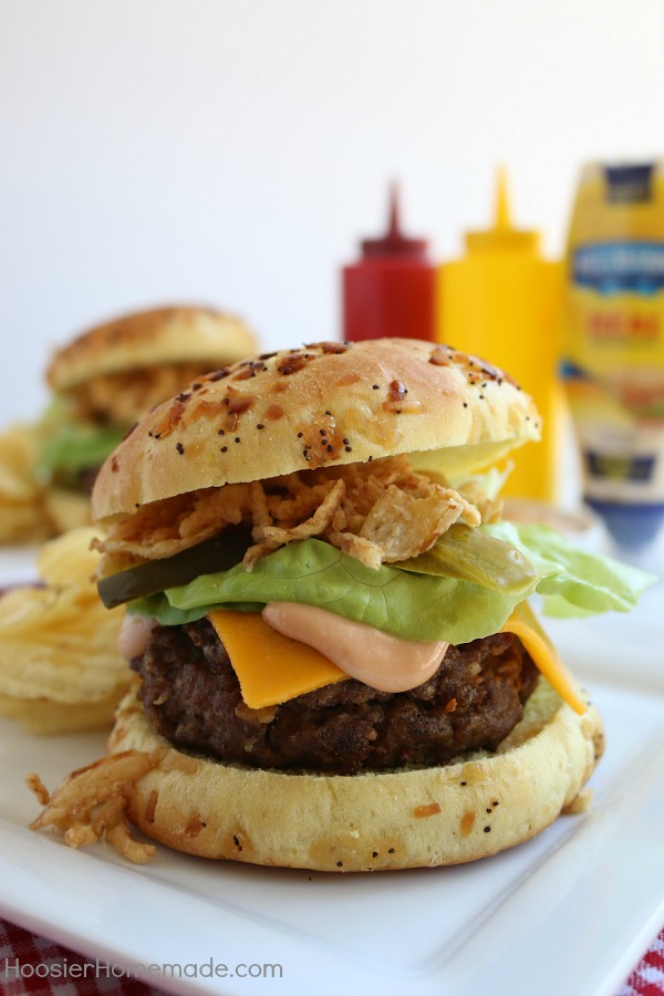 This All-American Barbecue Burger is the BEST you will ever eat! Made with a secret ingredient and piled high with barbecue/mayo sauce, cheese, lettuce and pickles all on a special onion bun! 