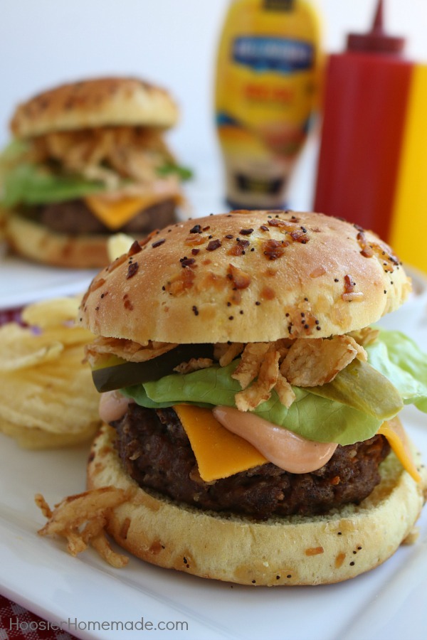 This All-American Barbecue Burger is the BEST you will ever eat! Made with a secret ingredient and piled high with barbecue/mayo sauce, cheese, lettuce and pickles all on a special onion bun! 