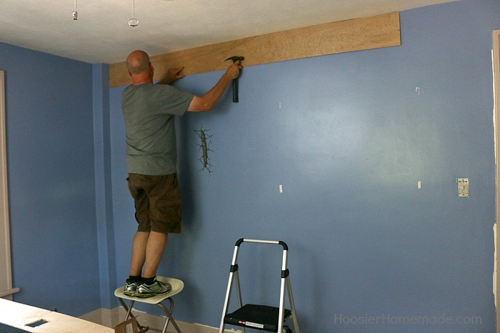 Hanging the first piece of DIY shiplap.