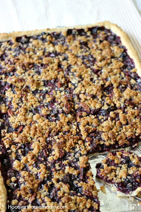 This flaky, single layer pie crust is filled with plump, juicy blueberries and topped with a crumb topping with pecans. Blueberry Slab Pie is perfect for your Summertime Parties, Father’s Day, Fourth of July or take along to a Potluck.