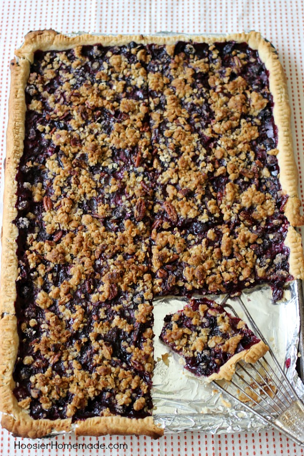 This flaky, single layer pie crust is filled with plump, juicy blueberries and topped with a crumb topping with pecans. Blueberry Slab Pie is perfect for your Summertime Parties, Father’s Day, Fourth of July or take along to a Potluck.