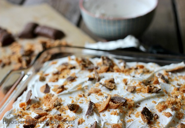 Butter Pecan Cake: Yellow Poke Cake flavored with Southern Butter Pecan Creamer, topped with Fluffy Frosting and chopped Butterfinger Candy Bars | Recipe on HoosierHomemade.com
