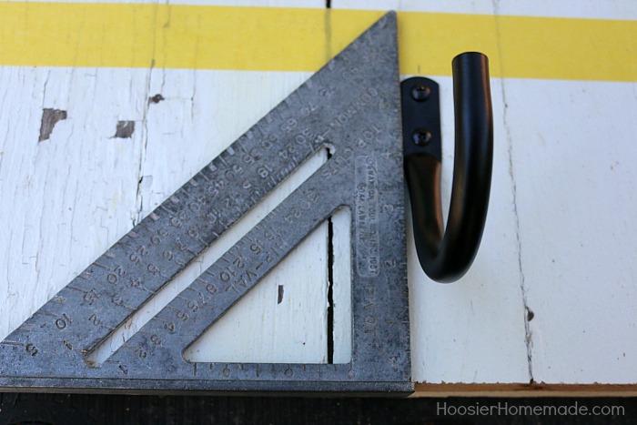 DIY COAT RACK -- This easy to make Farmhouse Coat Rack uses old barn wood and curtain tie backs! Build this coat rack for under $25!