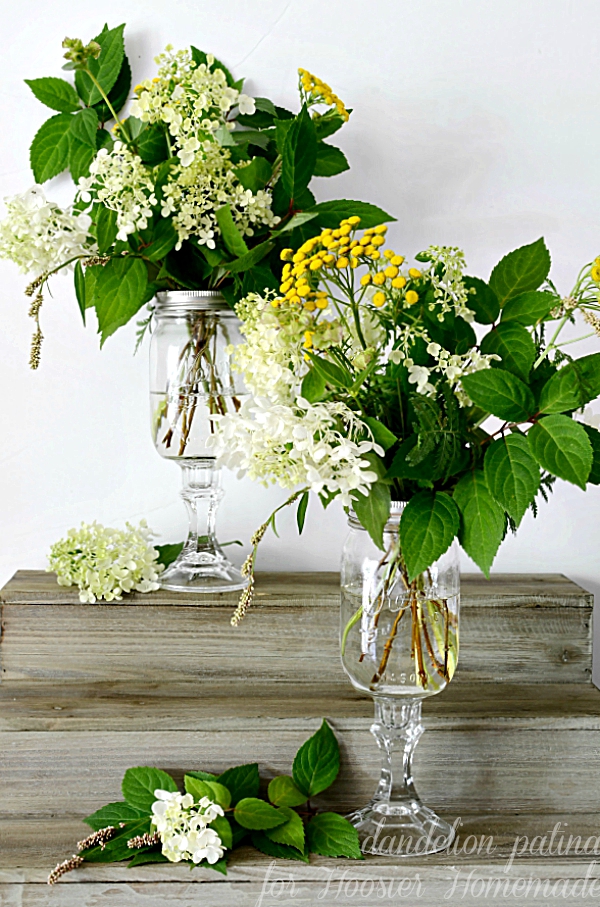 AMAZINGLY EASY PROJECT! Infuse your home with farmhouse style. These DIY mason jar vases are used to create beautiful arrangements from your backyard! No need to run to the floral shop any longer! This DIY created by Dandelion Patina for Hoosier Homemade. #farmhousestyle #masonjars