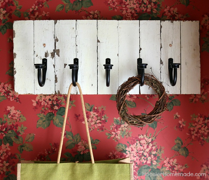 DIY COAT RACK -- This easy to make Farmhouse Coat Rack uses old barn wood and curtain tie backs! Build this coat rack for under $25!