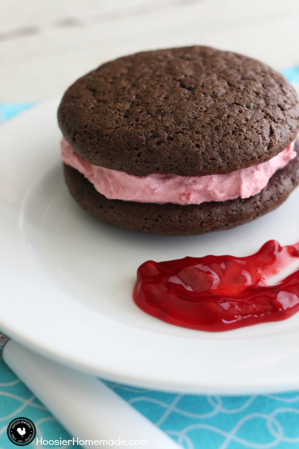 Raspberry Whoopie Pies - fluffy raspberry filling sandwiched between 2 chocolate cookies! Be sure to save room! You won't want to miss this one! Pin to your Recipe Board!