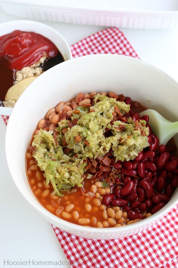 Baked beans in bowl with bacon and onions