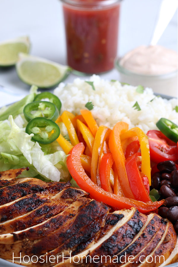 chicken, rice, peppers, beans, lettuce, tomatoes, jalapenos in bowl for burrito bowl recipe