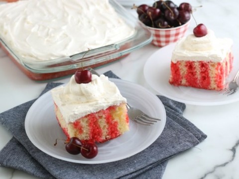 Cherry topped cakes on white plates.