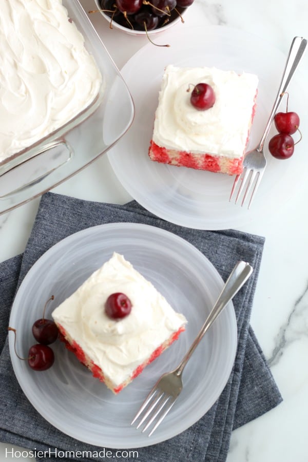 Cherry topped cakes on white plates.