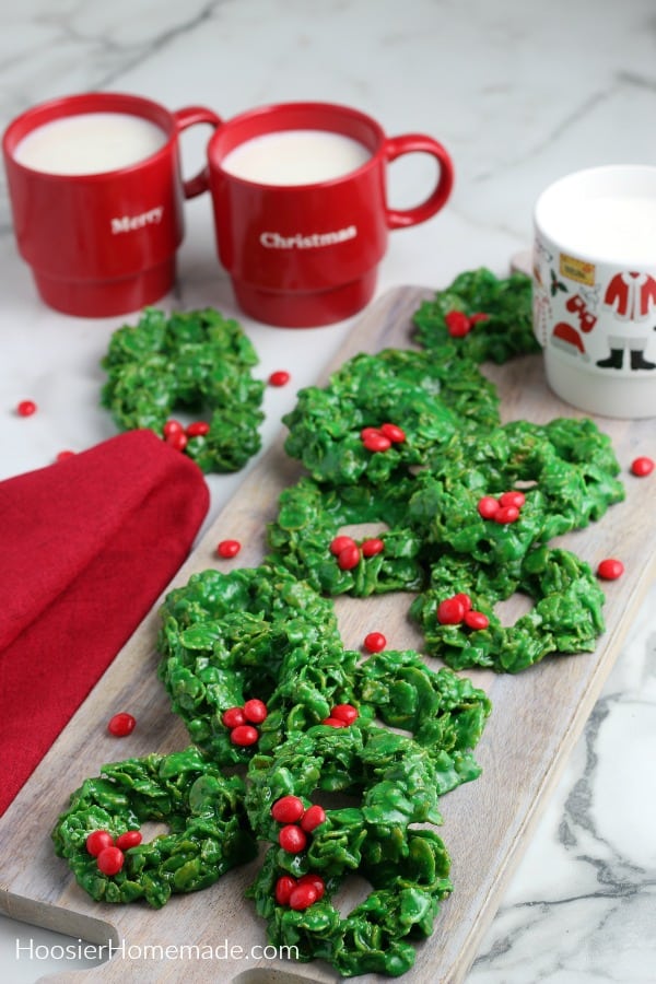 cornflake cookies on a board with milk in mugs 