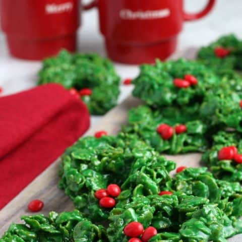 wreath cookies on board with mugs of milk