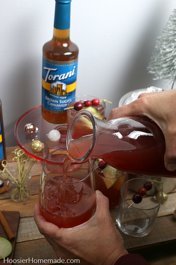 Pour cranberry and apple juice into glass