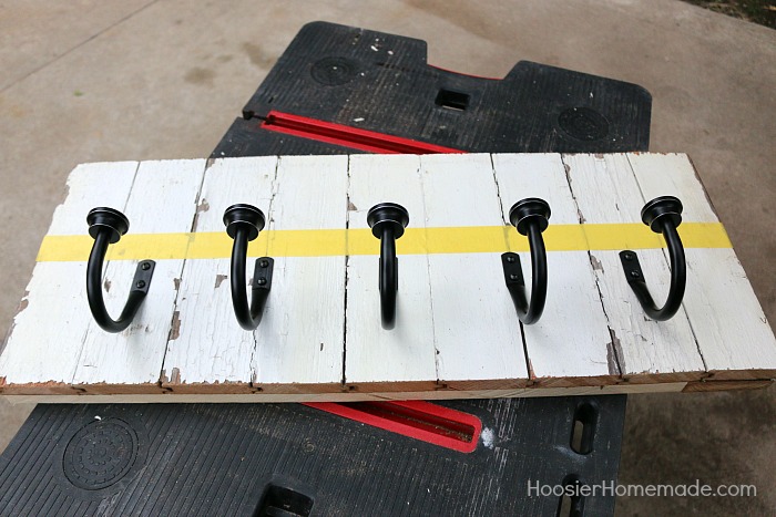 DIY COAT RACK -- This easy to make Farmhouse Coat Rack uses old barn wood and curtain tie backs! Build this coat rack for under $25!