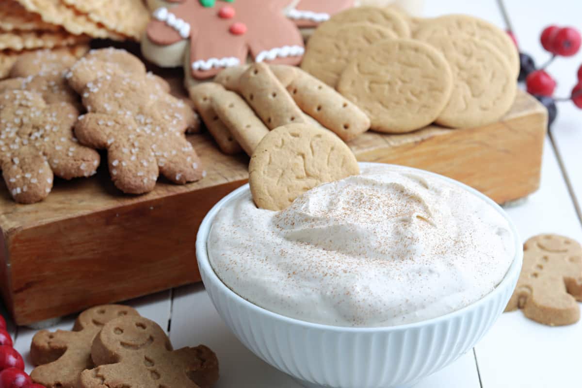 eggnog dip in white bowl with cookie