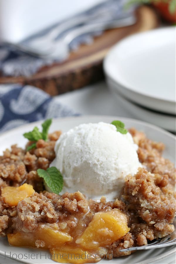 Peach Crisp on white plate with vanilla ice cream 