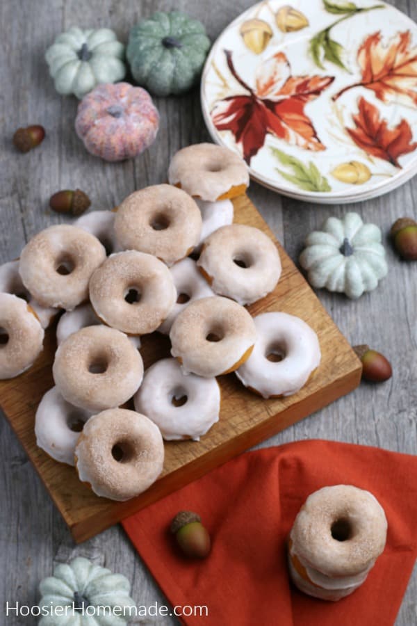 pumpkin donuts with icing and sugar on cutting board